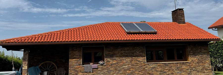 Casa con tejado de teja limpio y paneles solares